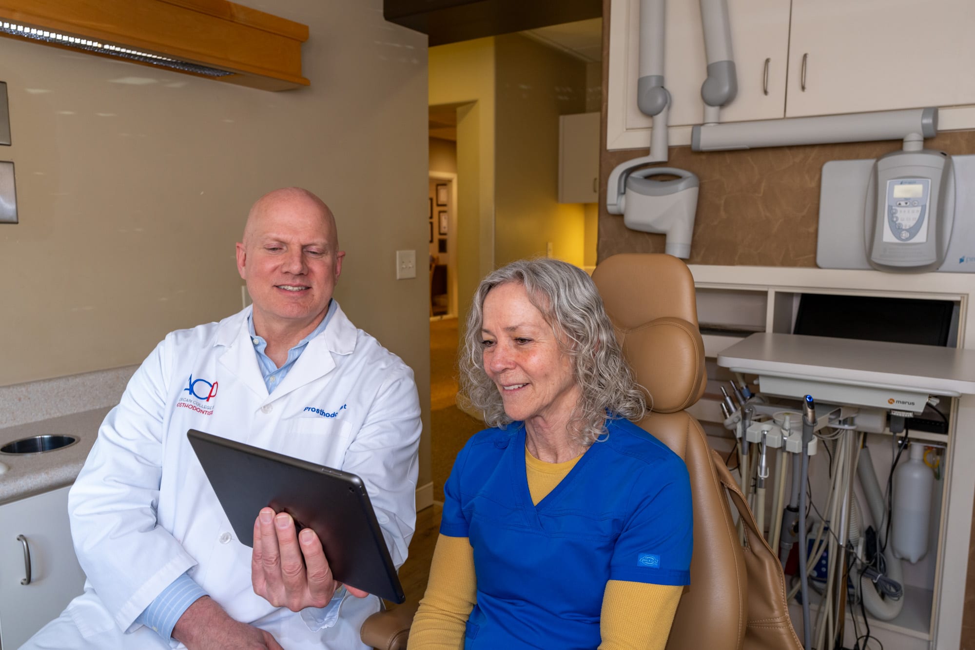Dr. Andrus reviewing treatment details with a patient on an iPad chairside